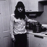 a man with a beard standing in a kitchen