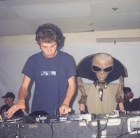 a man is djing with an alien in front of him